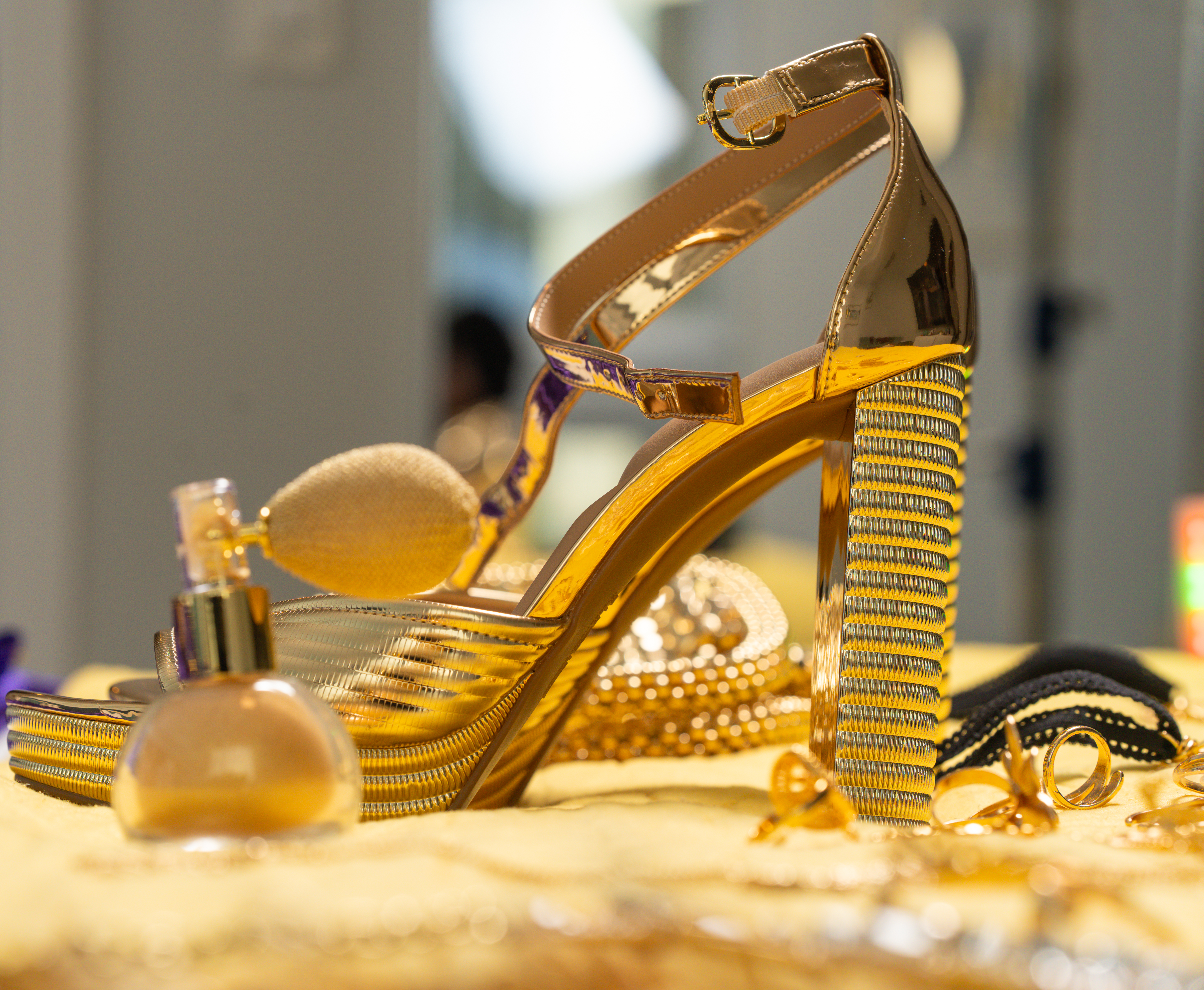 Commercial product-style photograph of gold heels, perfume, jewelry, and styling accessories by Big Rich Visuals